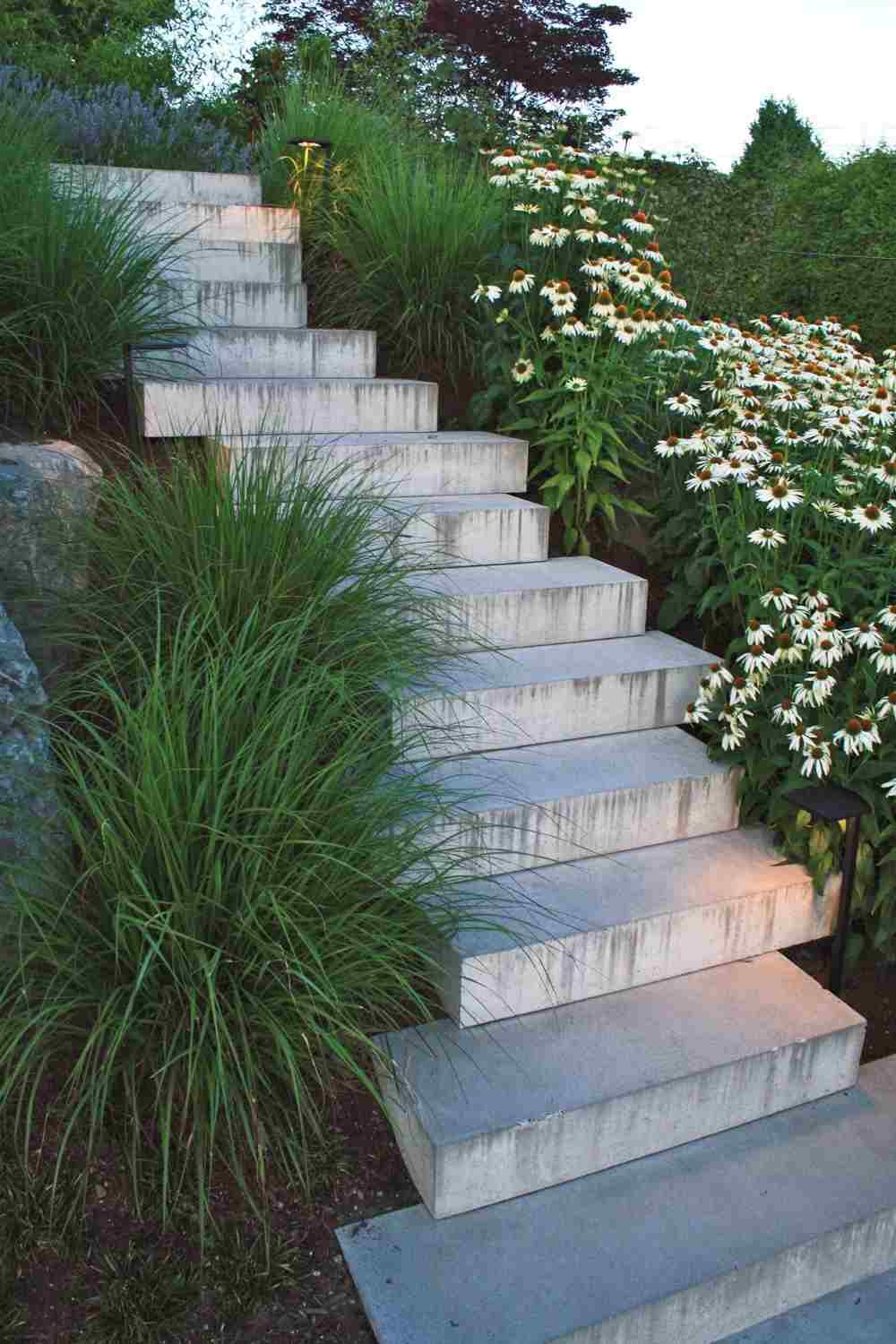 creative hanging of concrete stairs and green plants with flowers for gardening
