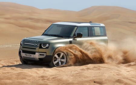 mattgrünes fahrzeug fährt im sand mitten in der wüste