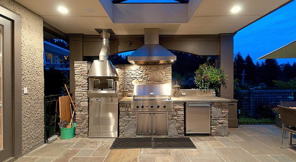 toll looking stainless steel exterior with grill and natural stone wall cladding