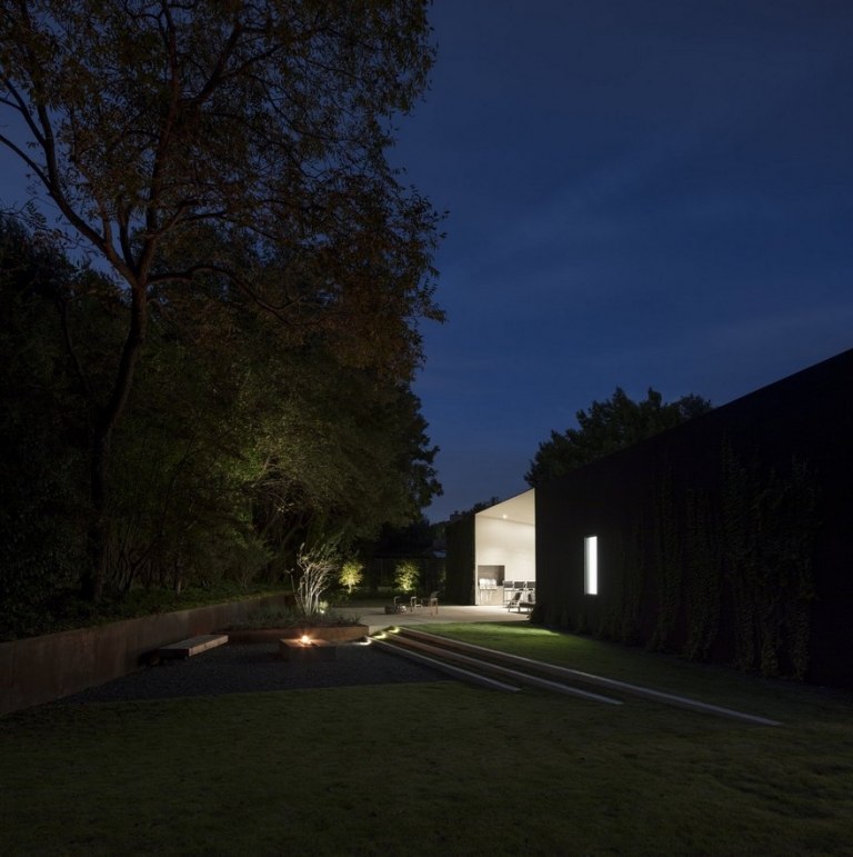 Einfamilienhaus mit Rasen und Feuerstelle im Garten Ideen für umweltfreundliche Beleuchtung