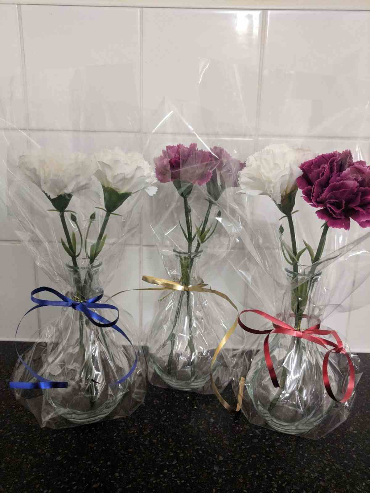 Geschenke schön verpacken mit Folie - Idee für Vasen mit Nelken
