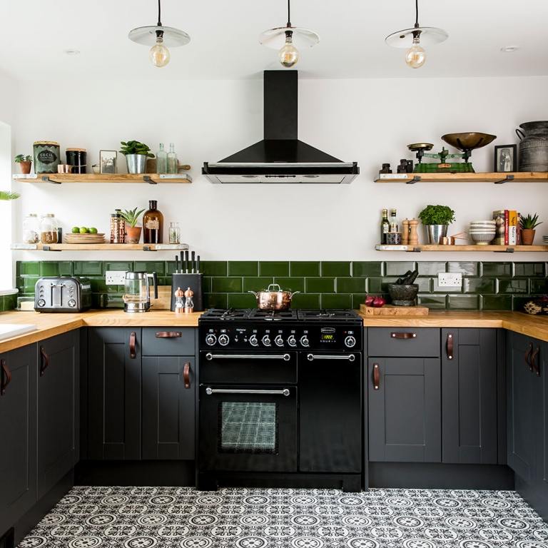 Küche mit Arbeitsplatte aus Holz moosgrüner Fliesenspiegel und schwarze Küchengeräte