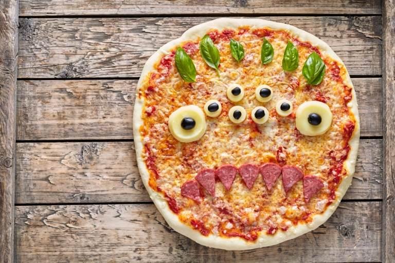 Halloween Pizza wie ein Monstern gestalten mit vielen Augen und Zähnen aus Salami