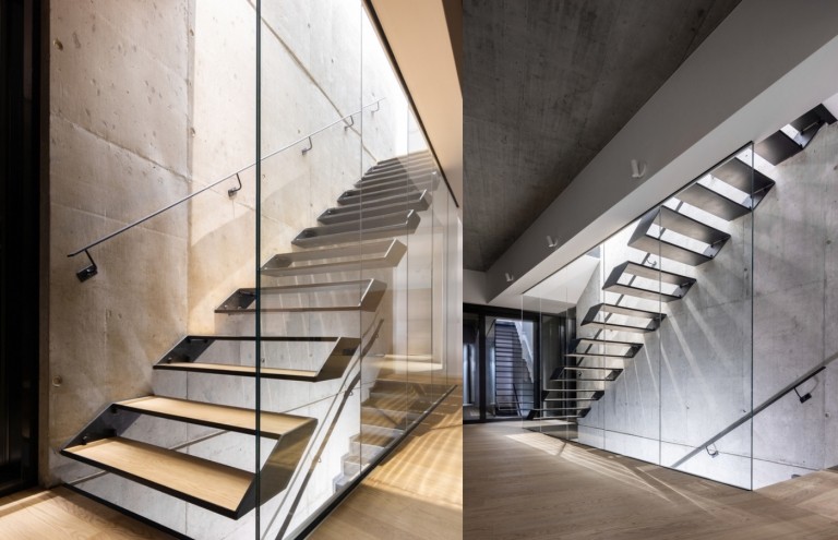 Innenarchitektur mit Sichtbetonwänden und Treppenhaus aus Holz und Metall-Geländer