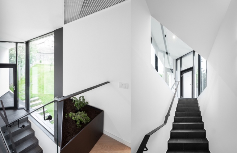 Moderne Innenarchitektur mit Treppe mit Schieferfliesen und weiß gestrichene Wände 