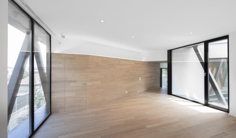 schmale Räume mit bodengleichen Fenstern und weiße Decke und Dielenboden