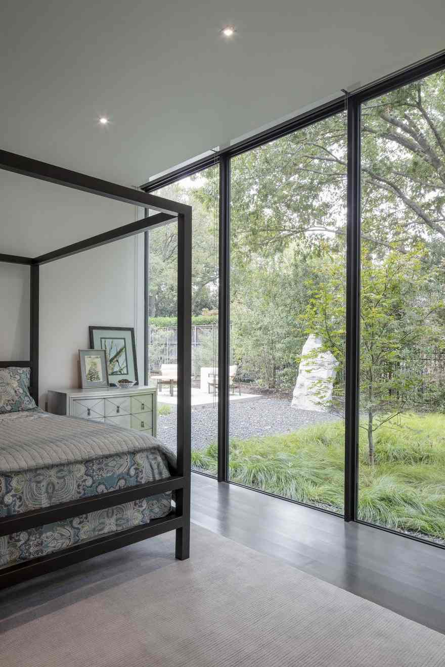 Himmelbett im Schlafzimmer im Erdgeschoss innen gedämmt Glasschiebetüren und Fensterfronten bieten Blick zum Garten