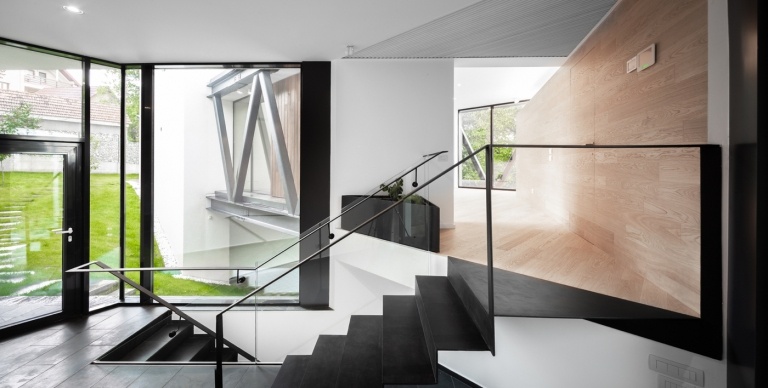 Kleines Einfamilienhaus mit Treppenhaus mit Glas Geländern und Räumen mit in Holz verkleideten Wänden