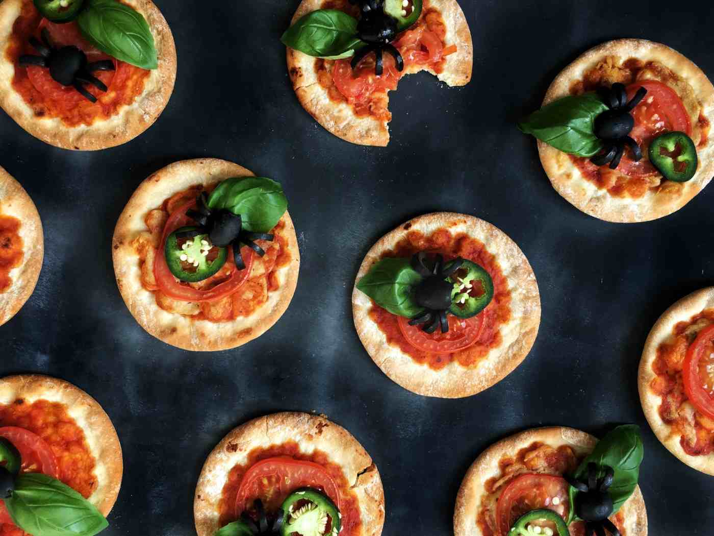 Mini-Pizzen mit Tomaten, Chili und Spinnen aus Oliven sind lecker und dekorativ