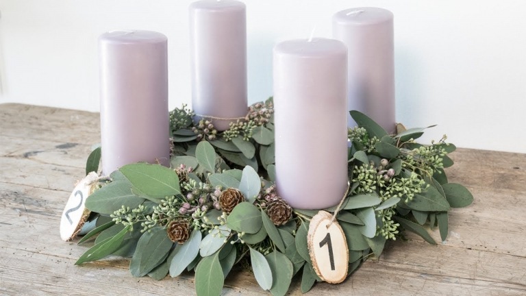 Moderne Adventsgestecke basteln Weihnachtsgestecke mit Lavendel Kerzen und Lorbeerzweigen und Tannenzapfen und Holzscheiben