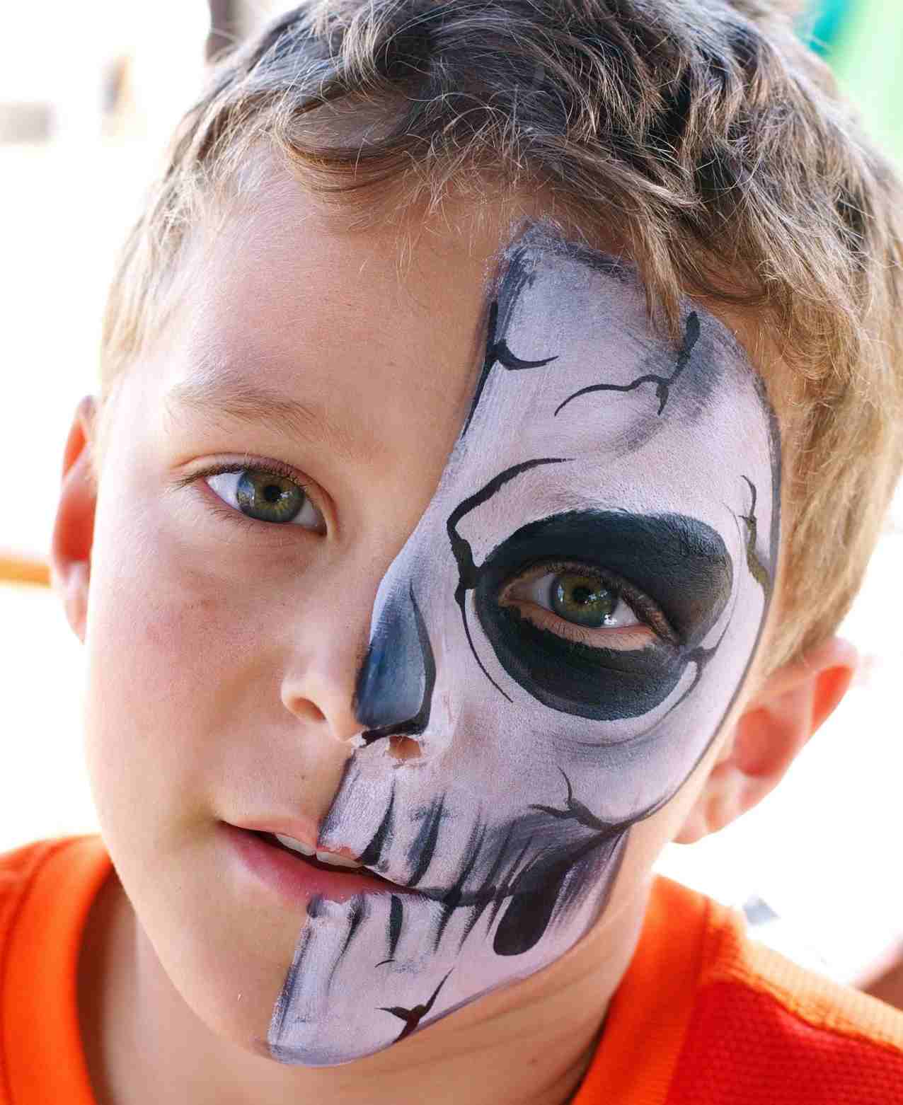 Totenkopf schminken Skelett am halben Gesicht malen Halloween Make-up Ideen für Kinder