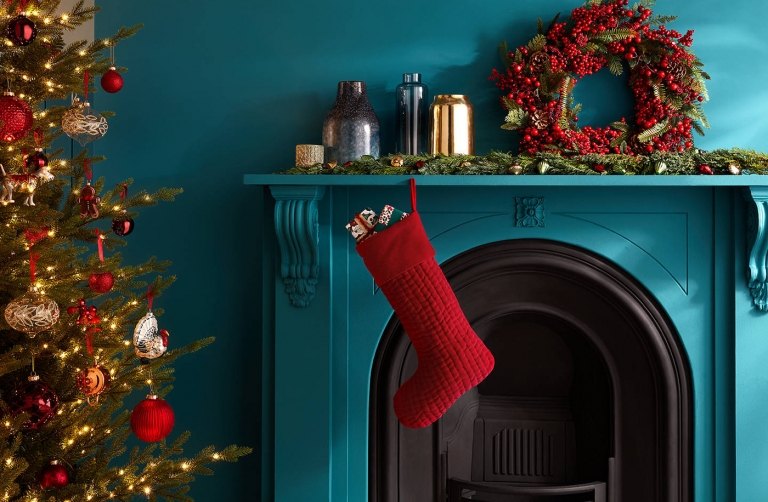 Trendfarben Weihnachten 2019 Türkranz aus Tannenzweigen und Beeren und roter Weihnachtsstiefel