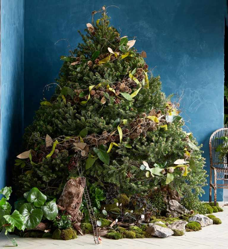 Weihnachtsbaum festlich schmücken mit Naturmaterialien wie Girlande aus Tannenzapfen und puristischer Tannenbaumteppich aus Moos