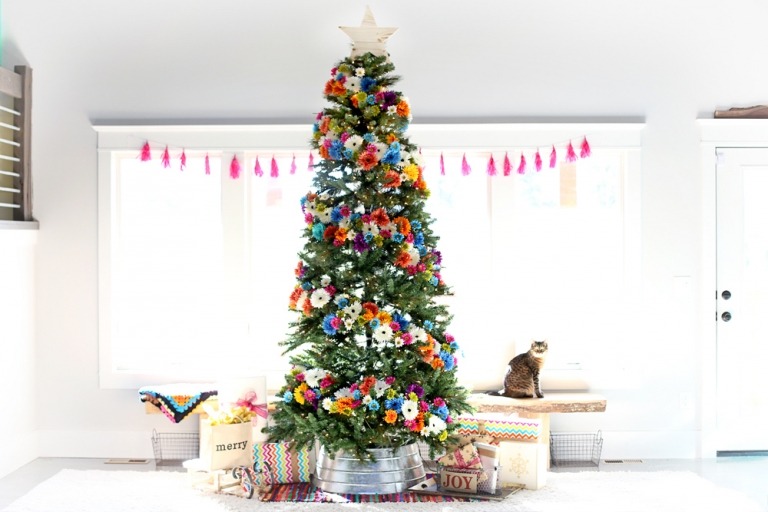 Weihnachtsbaum schmücken Trends mit Naturmaterialien echte Girlande aus Blumen und Stern aus Holz als Christbaumspitze moderne Dekoidee