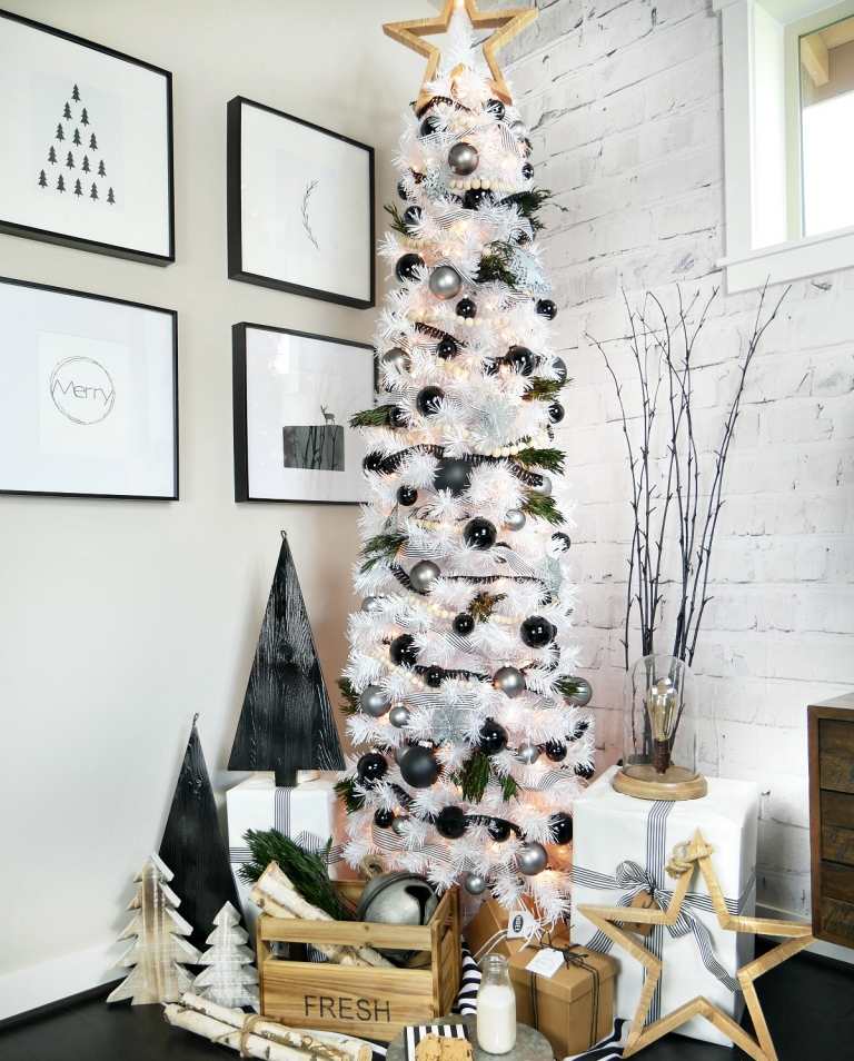 Weihnachtsbaum schwarz weiß geschmückt moderne minimalistische Optik mit Holzstern und weißer Christbaum und schwarzen und silbernen Weihnachtsbaumkugeln