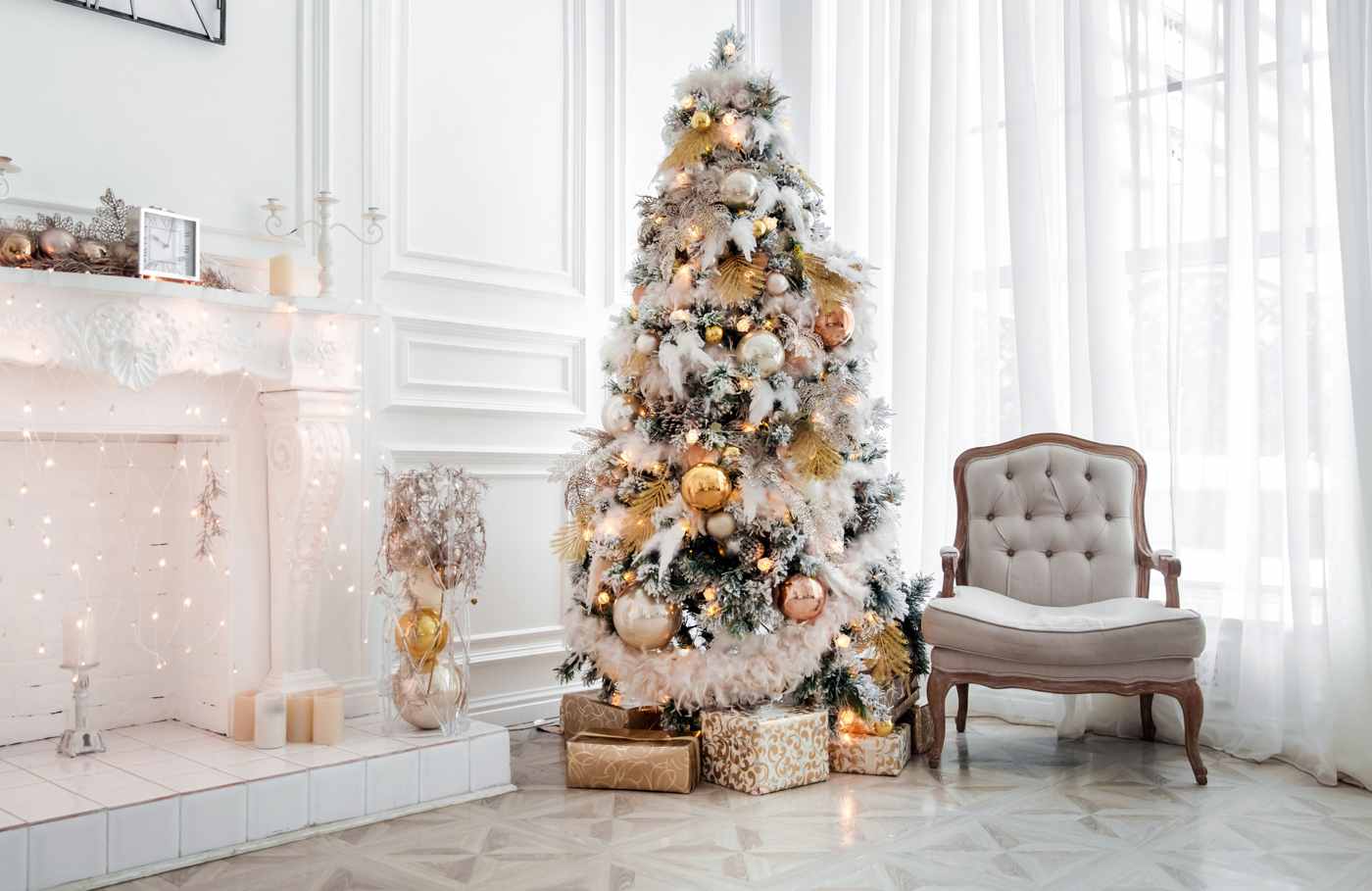 Weihnachtsbaum weiß gold geschmückt festliche Weihnachtsdeko mit Lichterketten und Goldkugeln Christbaum neben dem Kamin