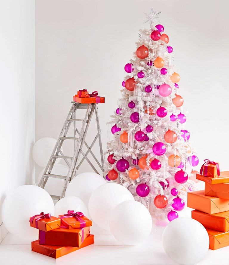 Weihnachtsdeko Ideen im modernen Stil künstlicher Christbaum mit halbtransparenten orange und pinke Weihnachtskugeln