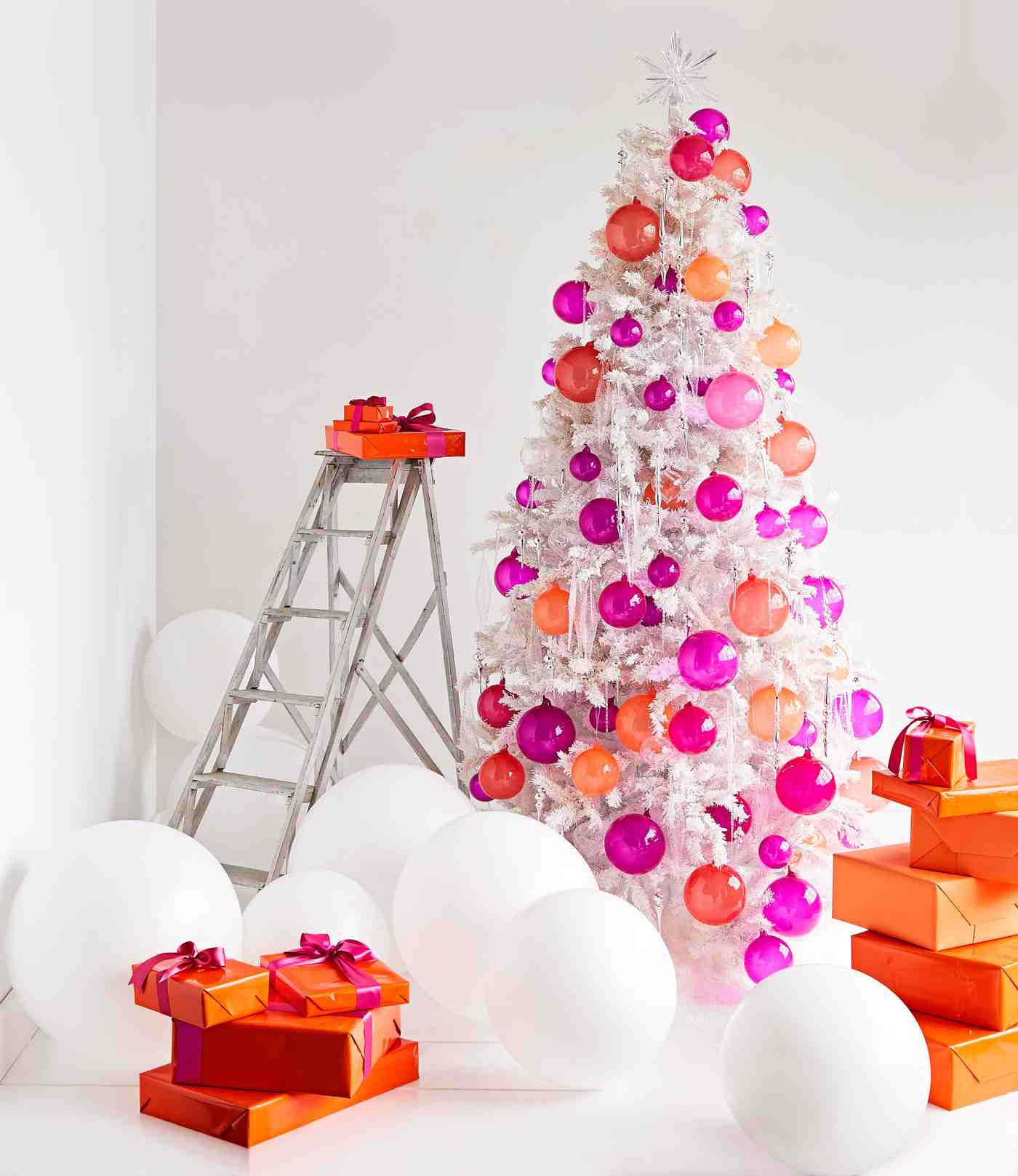Weihnachtsdeko Ideen im modernen Stil künstlicher Christbaum mit halbtransparenten orange und pinke Weihnachtskugeln