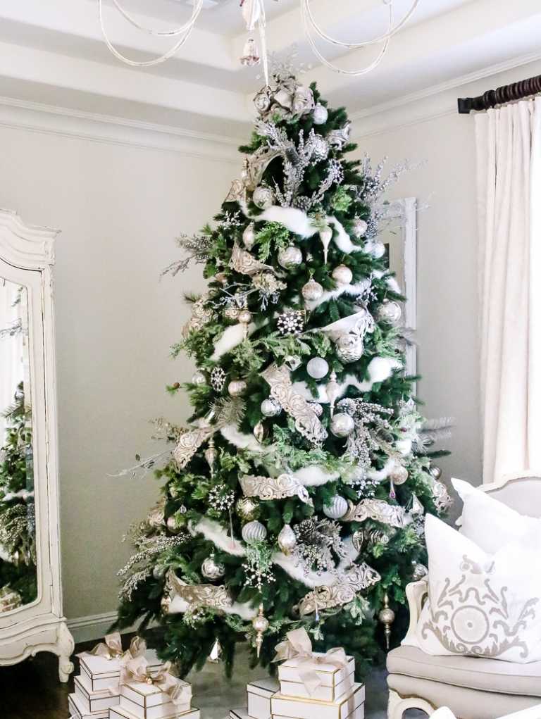 klassische Weihnachtsdeko Idee mit Girlande und silbernen Weihnachtsbaumkugeln und Schneeflöcke als Tannenbaumspitze