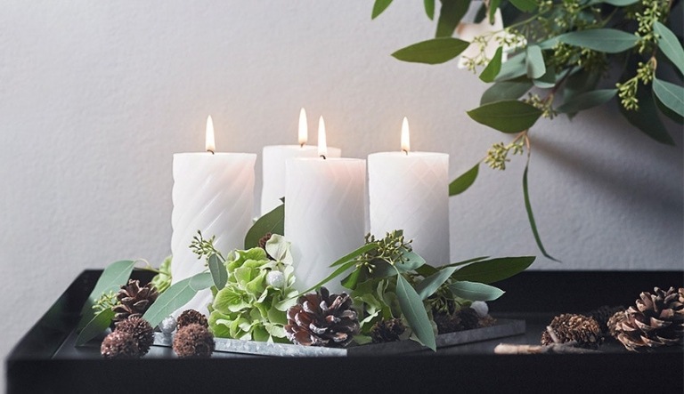 Weihnachtsgestecke aus Naturmaterialien Bastelideen mit immergrünen Baumblättern und weißen Kerzen