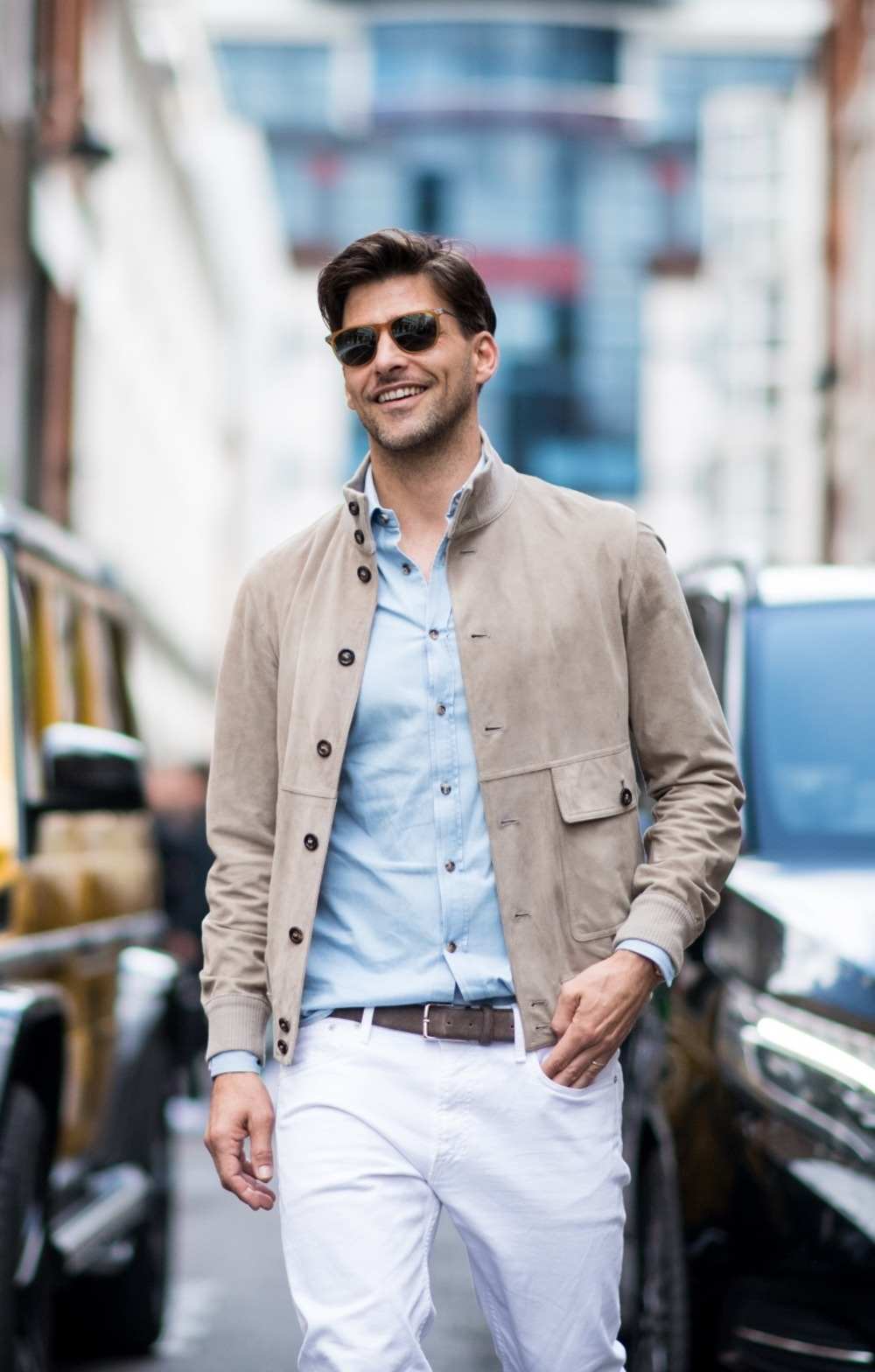 freizeitkleidung mit hellen farbtönen bestehend aus beigefarbener jacke hellblauem freizeithemd und weißer jeanshose mit ledergürtel