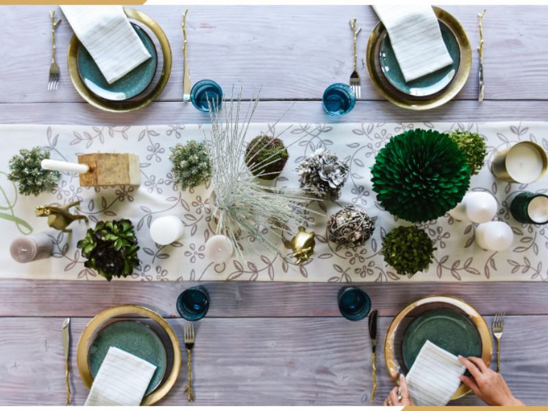 gedeckter Tisch zu Weihnachten in Gold und Smaragdgrün mit echten Pflanzen