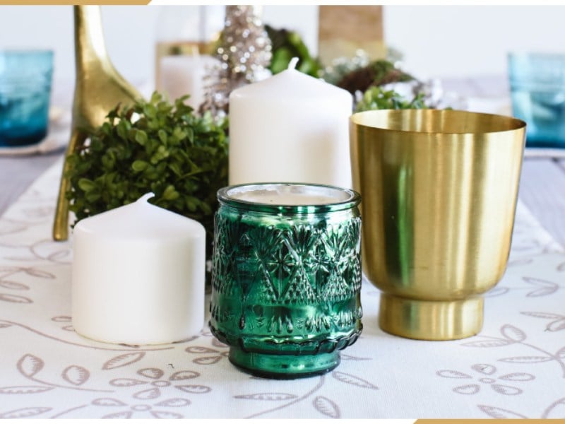 gedeckter Tisch zu Weihnachten mit Windlichtern und Vasen und Heckenpflanzen
