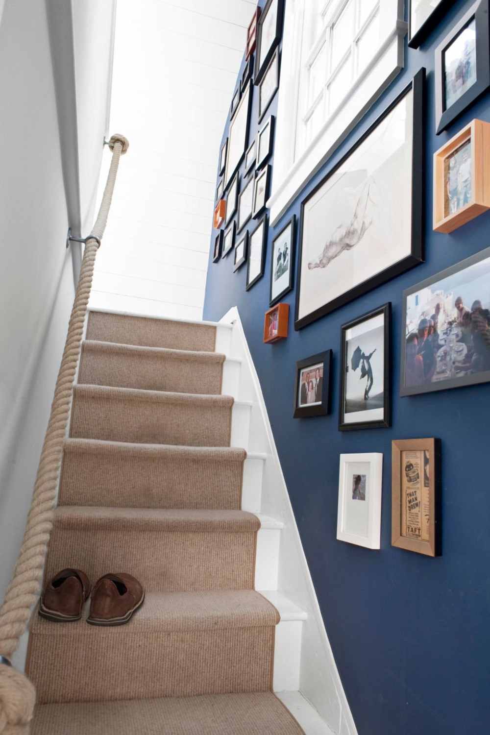 hellbrauner teppichläufer auf treppen mit treppenwand in blau dekoriert mit fotos