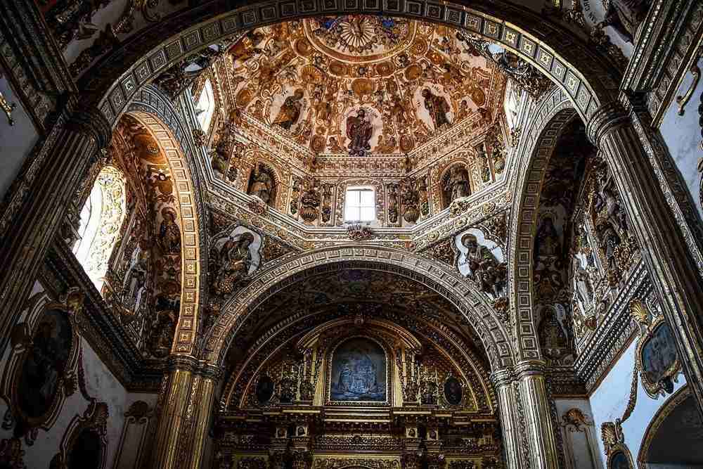 innenraum von einer mexikanischer kirche mit vielen ikonen und goldenen elementen