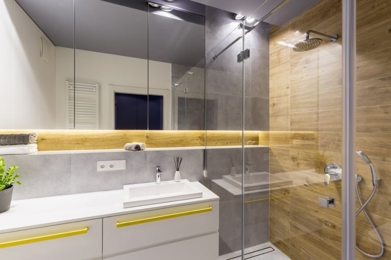  kleines Badezimmer gestalten Duschkabine indirekte Beleuchtung Natursteinfliesen und großer Badspiegel
