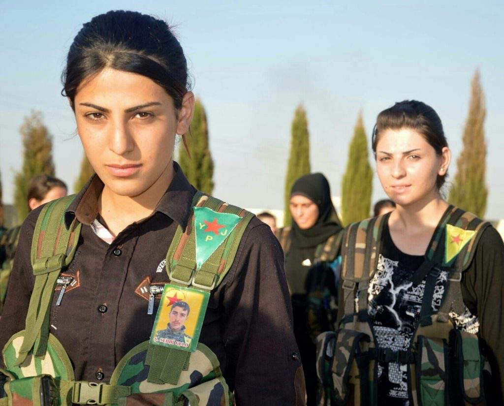 kurdische Frauen mit dunklen Haaren und brauen Augen in Militär-Ausrüstung