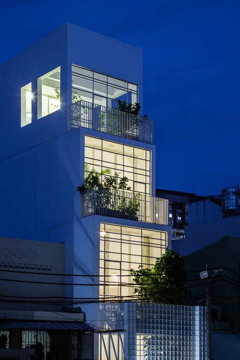 leuchtende fenster fassaden von engem gebäude mit praktischem grundriss und balkons