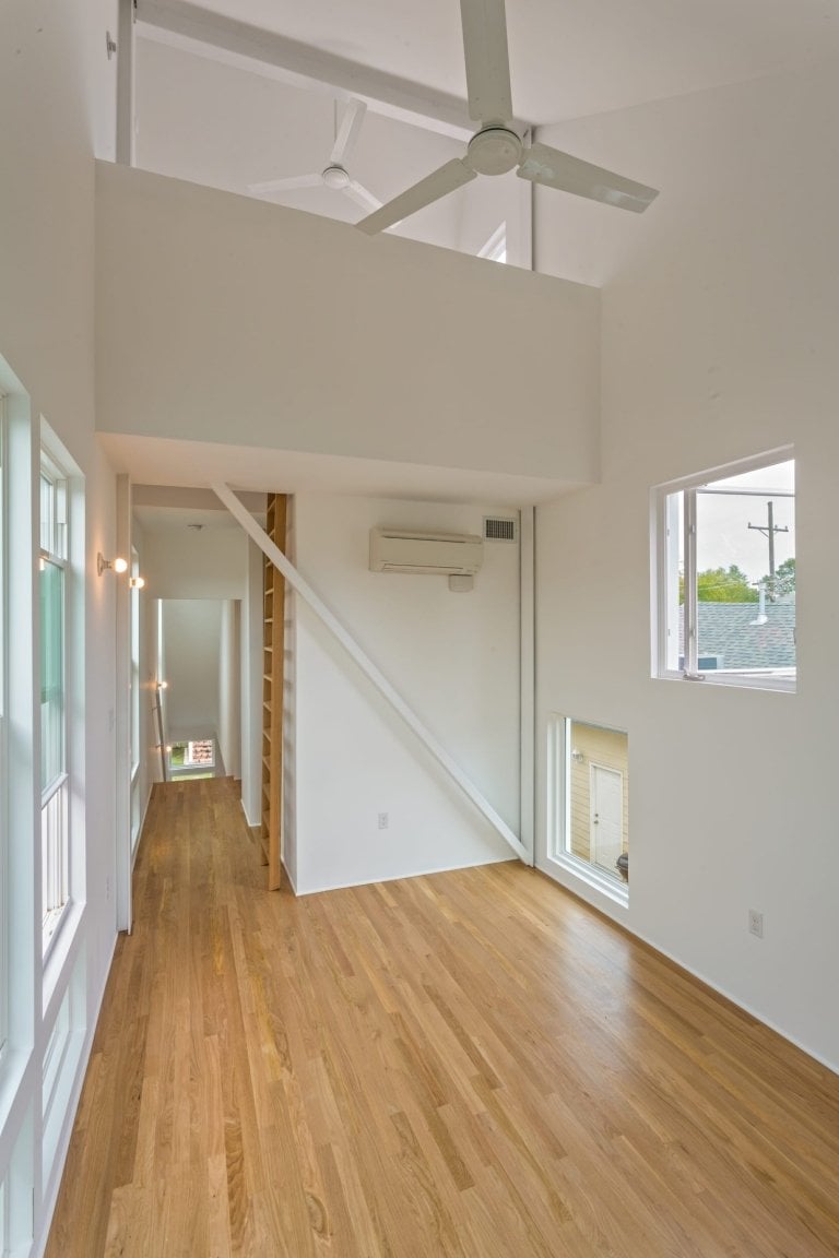 minimalistischer innenraum mit laminatboden und holzleiter mit praktischer raumaufteilung