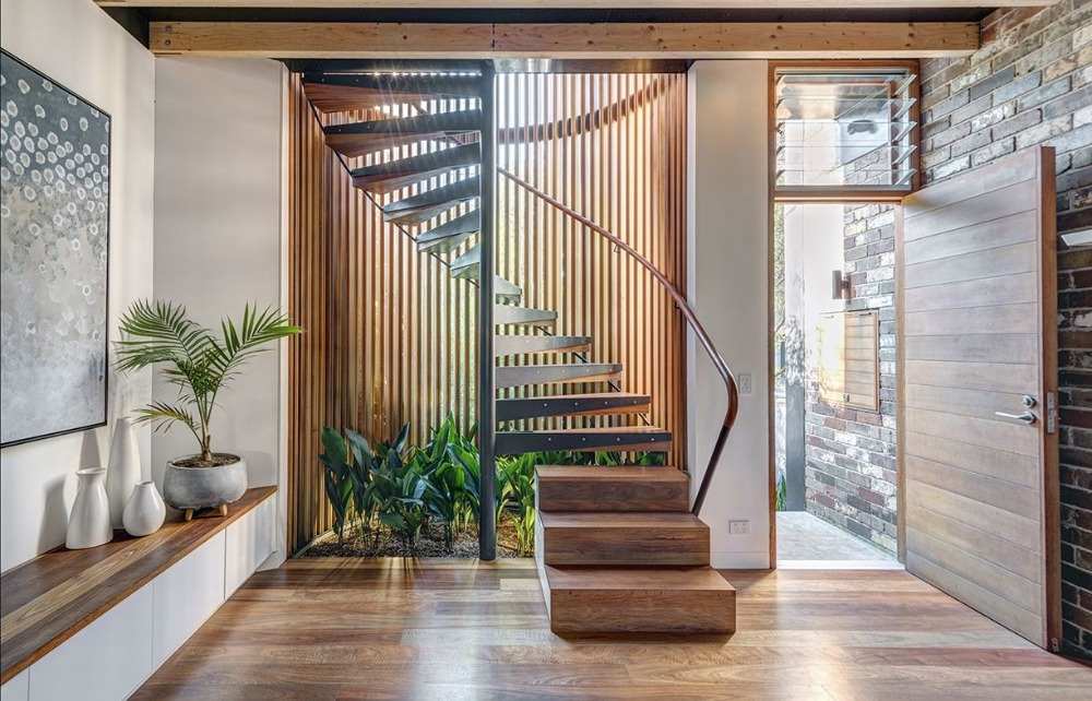 modern renovierte wendeltreppe mit zeitgenössischem design aus holz und eisen im eingangsbereich