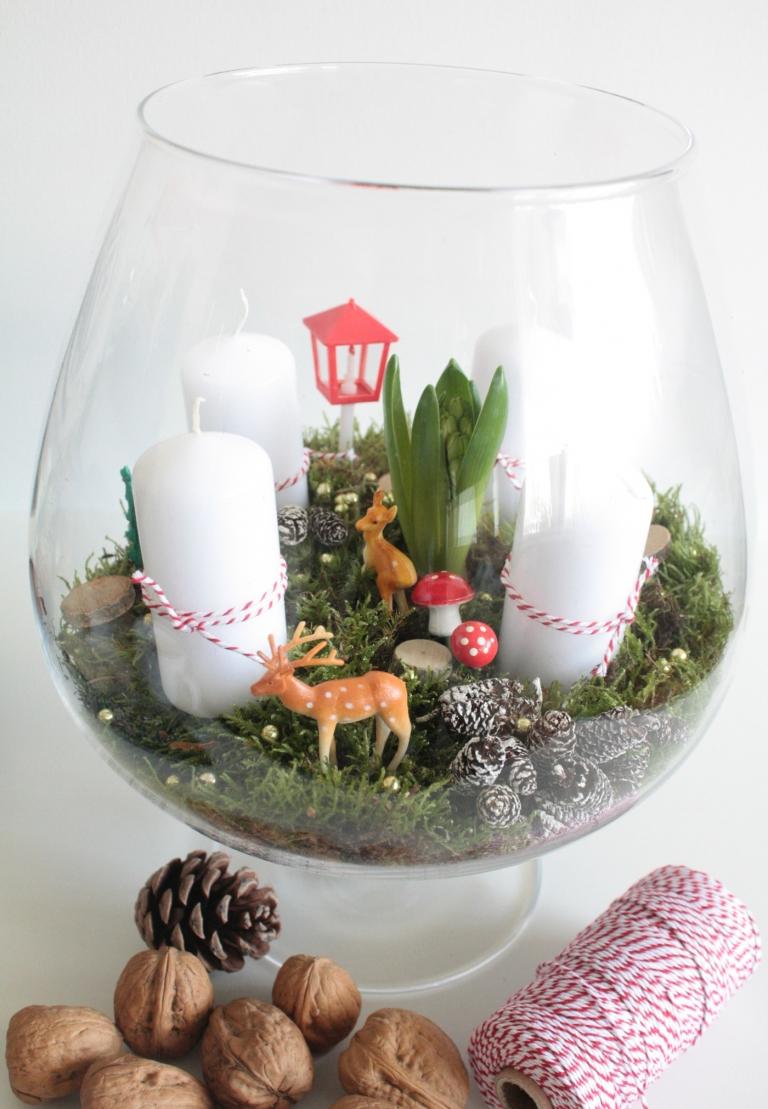 moderne Adventsgestecke in Glas basteln Zierfiguren Moos Tannenzapfen Krokusblume weiße Kerzen