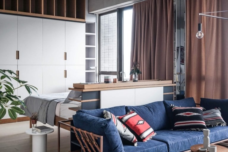moderne Wohnung mit Sofa Doppelbett und Kommode als Raumteiler