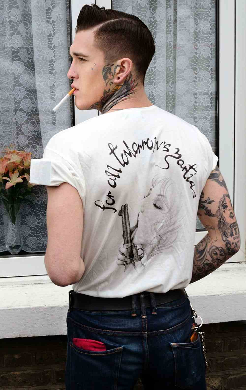 rebellische rockabilly frisur mann mit weißem t-shirt und zigarette sowie nacken tattoo