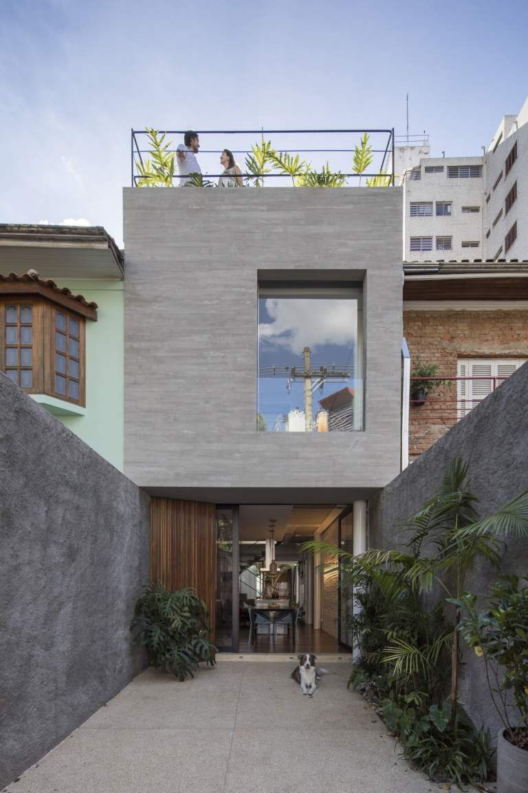 städtisches zuhause mit betonfassade und innenhof sowie dachterrasse neben schmale häuser
