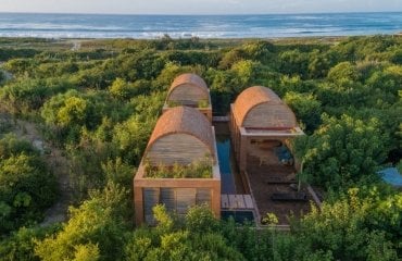 traumhafte villa mit gewölbten dächern aus ziegelsteinen und langem pool neben ozean