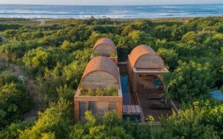 traumhafte villa mit gewölbten dächern aus ziegelsteinen und langem pool neben ozean