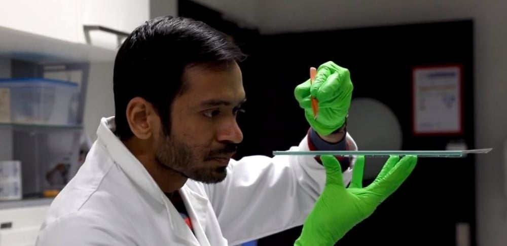 wissenschaftler testet ergebnis im labor mit grünen gummihandschuhen