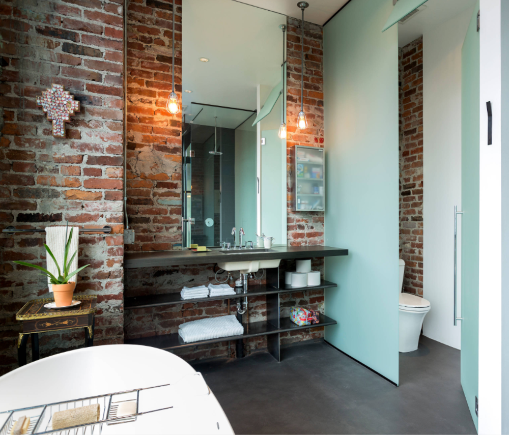 brick wall with pendant light and shiny light next to the bathroom and bedroom