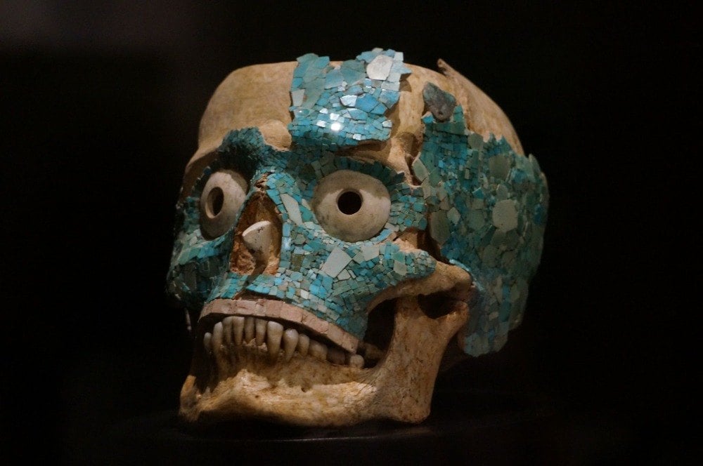 zur ausstellung im kulturmuseum oaxaca ein schädel mit türisfarbenen elementen