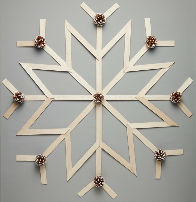 Bastelstiele aus Holz und kleine Tannenzapfen für eine Schneeflocke