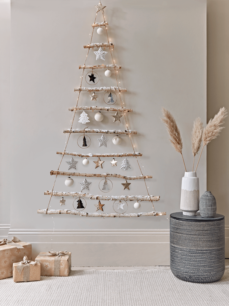 hängender weihnachtsbaum aus ästen mit dekorativem schnee bestreut im skandinavischen stil