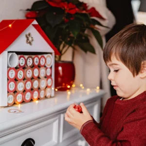 kleines kind nimmt schokolade aus handgemachtem adventskalender
