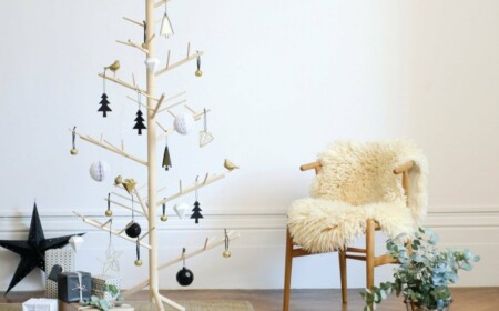 minimalistischer weihnachtsbaum aus holz im skandinawischen stil mit dekoration