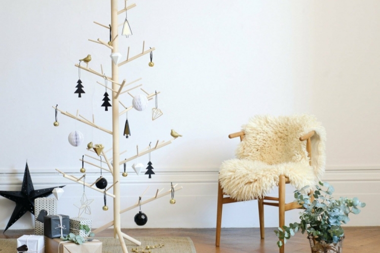 minimalistischer weihnachtsbaum aus holz im skandinawischen stil mit dekoration