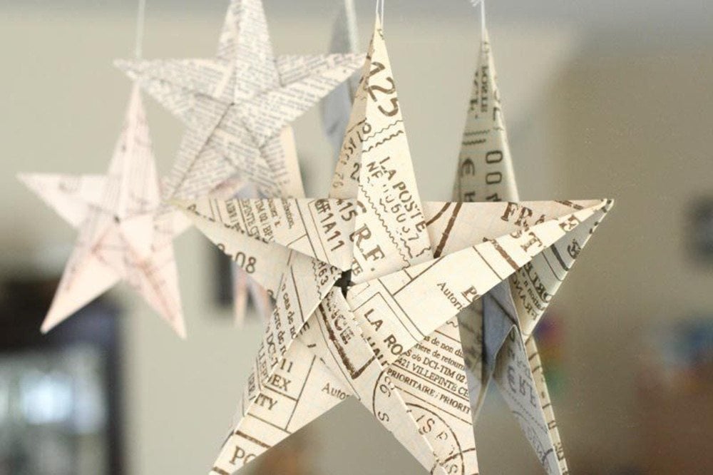 nach origami art gefaltete papiersterne aus verschiedenen blättern hängend im wohnzimmer