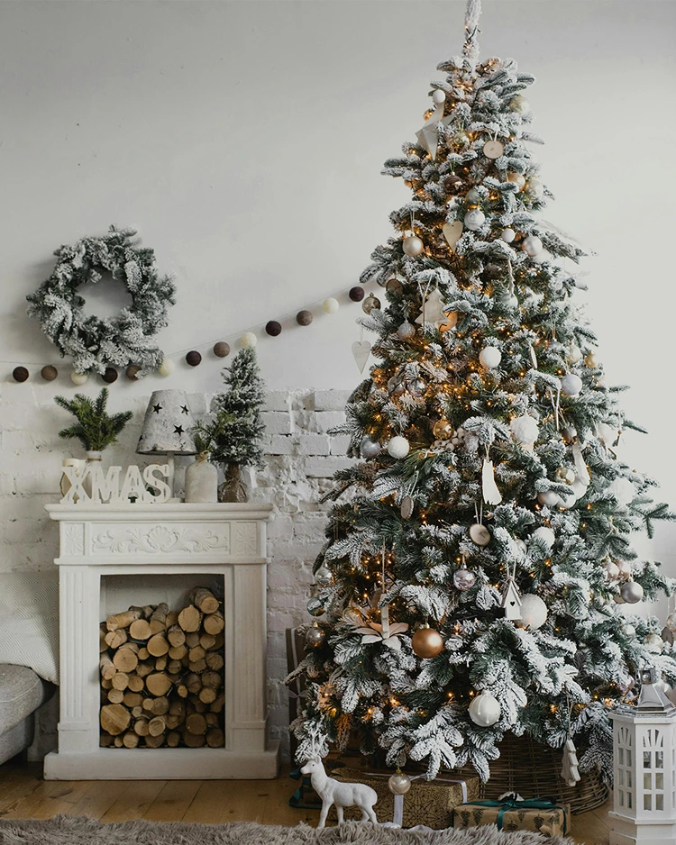 Weihnachtsbaum weiß geschmückt mit goldenen Akzenten und Kunstschnee